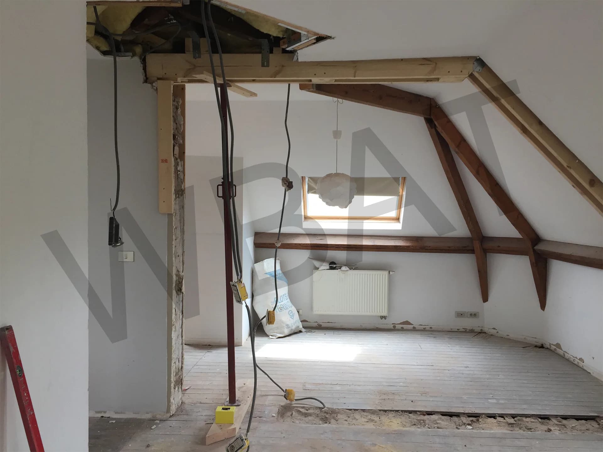 Combles avant travaux : charpente apparente, câbles et plancher brut