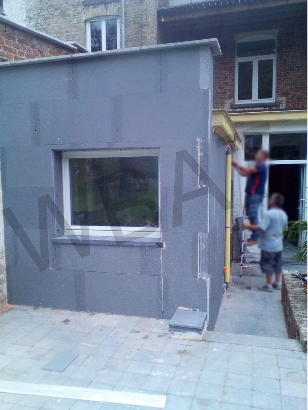 Application de l'enduit de fond sur la façade de l'annexe