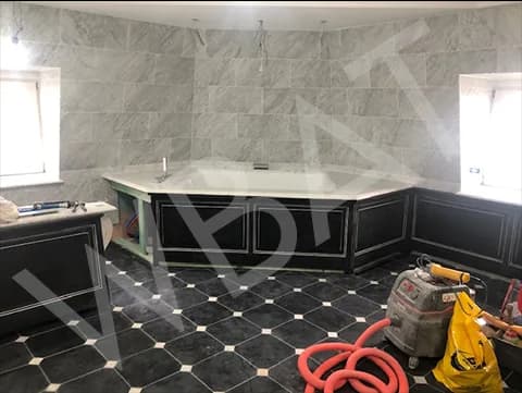 Salle de bain terminée : sol damier noir et blanc, baignoire encastrée