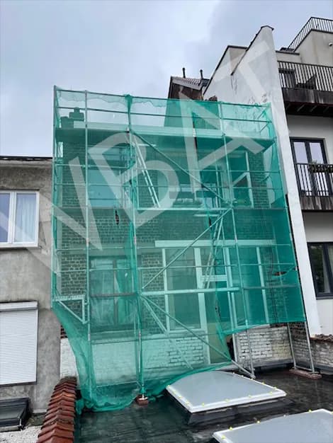 Rehausse en construction sous échafaudage et filet de protection